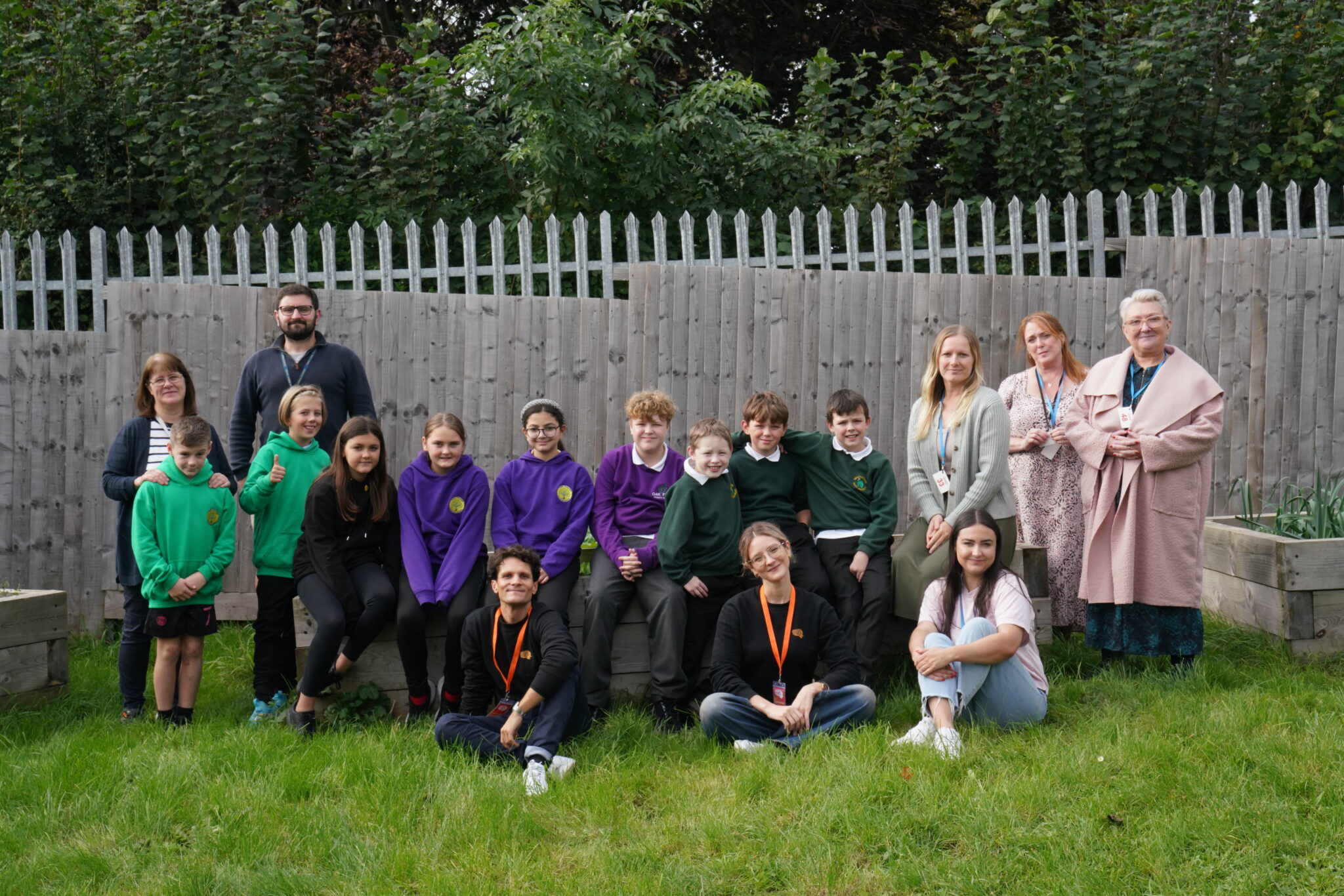 A diverse group of children and adults smiling and posing together for a group photo.