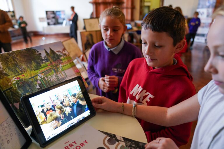 Children engrossed in a tablet.