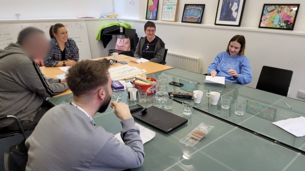 Five people collaborating on the Our Minds Our Future project in the ProMo Cymru office.