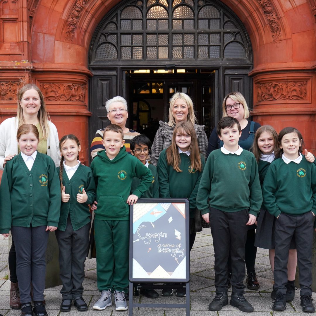 Children and adults of various ages gathered in front of the Pierhead building in Cardiff Bay.