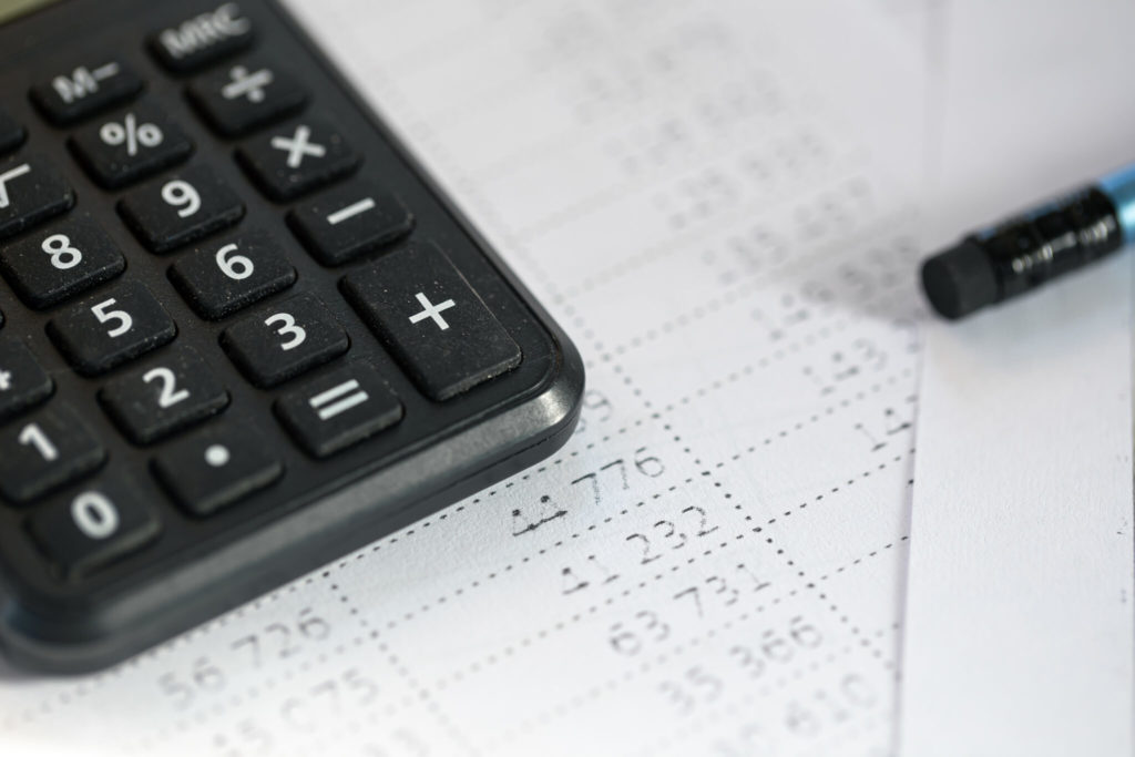 Calculator and pencil close-up on a blurred background.