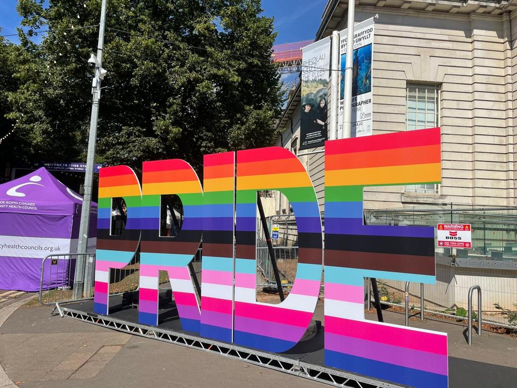 Large rainbow coloured letters spelling out pride