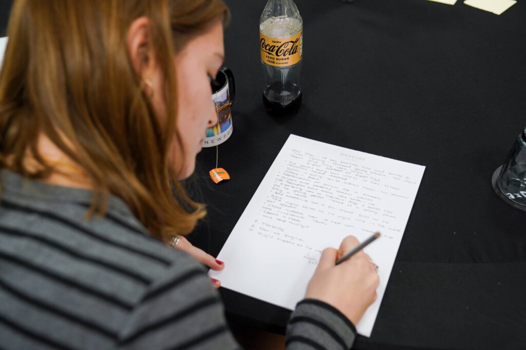 MoFG Peer Service Designer writing notes down on a piece of paper