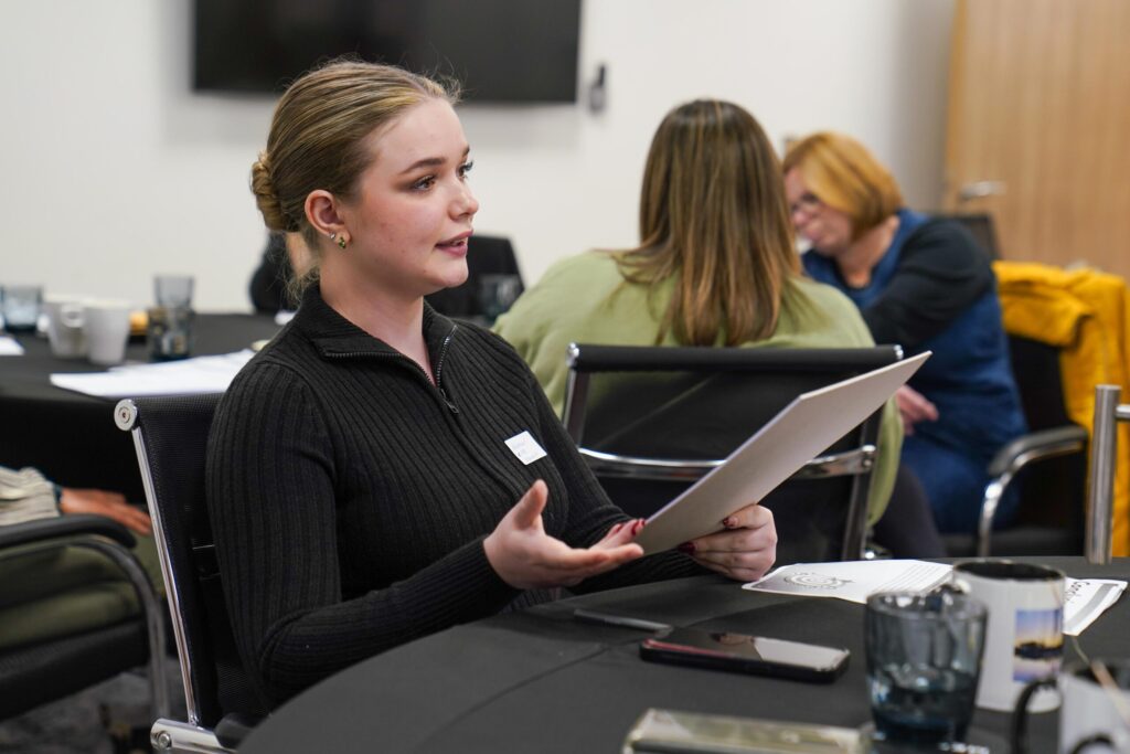 MoFG Peer Service Designer delivering feedback to professionals whilst reading from a sheet of notes