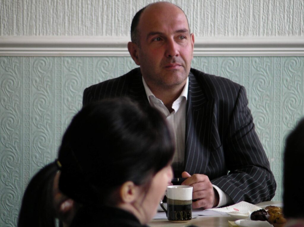 A man deep in thought at a meeting