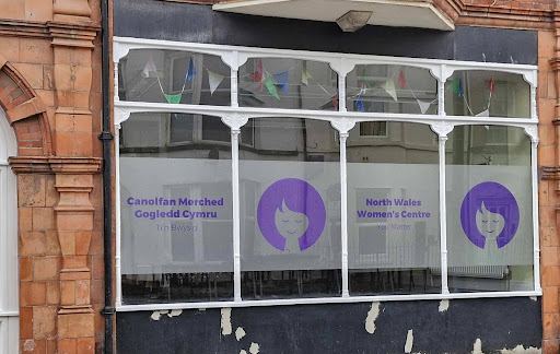 NWWC’s old logo. Four silhouettes of women doing different poses. Next to that is their new logo ProMo Cymru redesigned showing a circular cartoon of a woman's face smiling and looking peaceful, and the tagline “You Matter”.
